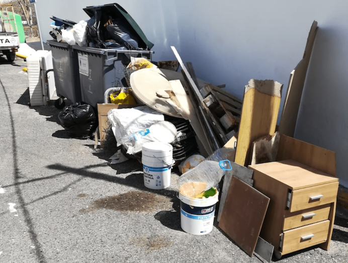 Imagen de los contenedores con basura esparcida junto a la vivienda (Foto TA)